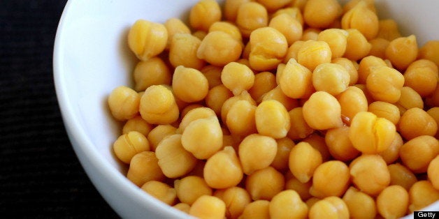 Chickpeas in white bowl over dark background.