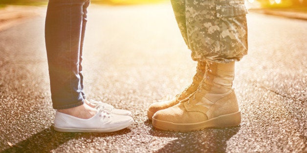 Young military couple kissing each other, homecoming concept, soft focus,warm orange toning applied