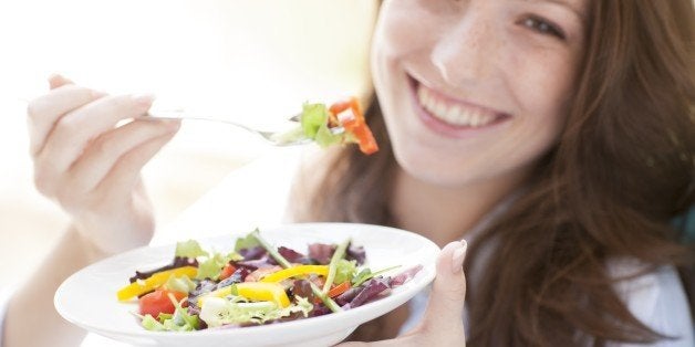 Young woman eating a salad.