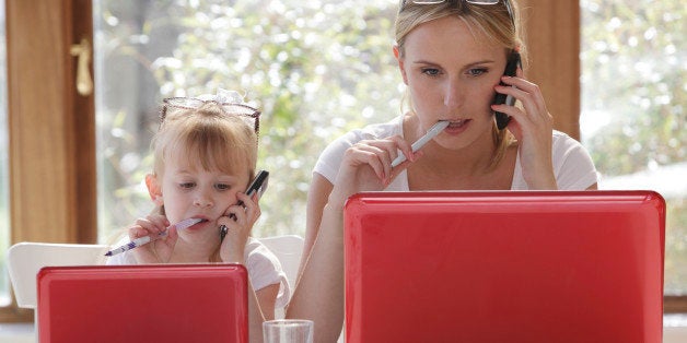 daughter copy mother working on laptop