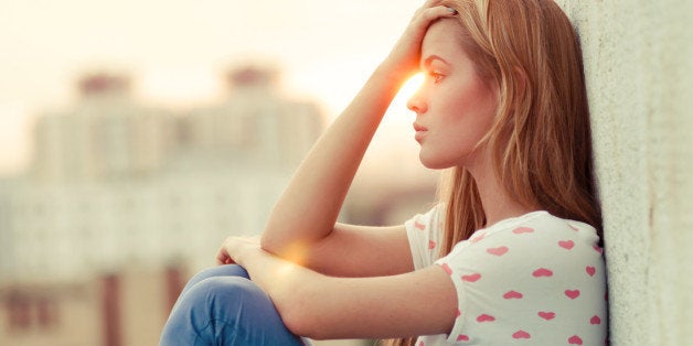 beautiful lonely girl sitting on the roof