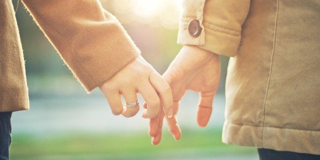 Happy couple holding hands in sunset light.