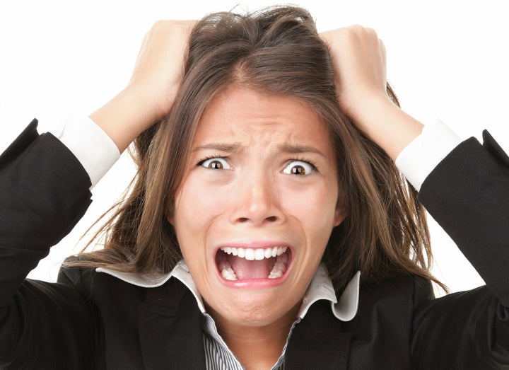 Stress. Woman stressed is going crazy pulling her hair in frustration. Close-up of young businesswoman on white.