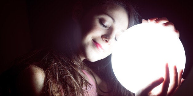 closeup image of beautiful young sleeping woman holding ball of light and smiling happily