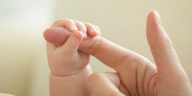 Mother and Newborn Baby Holding Hands