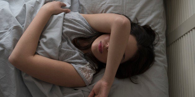 USA, New Jersey, Elevated view of young woman sleeping in bed