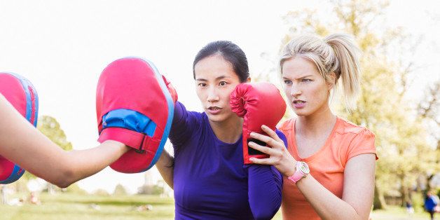 Female boxer being coached by fitness instructor