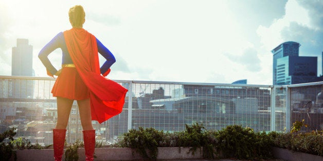 Superhero standing on city rooftop