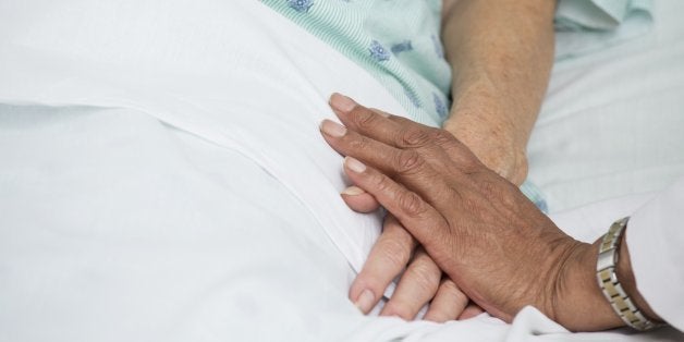 Doctor holding patient's hand in hospital