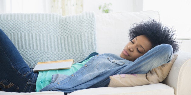 African American woman napping on sofa