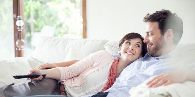 Couple watching TV together on sofa