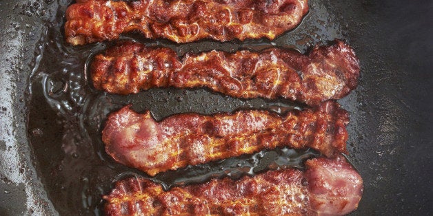 Bacon slice being cooked in frying pan. Close up.