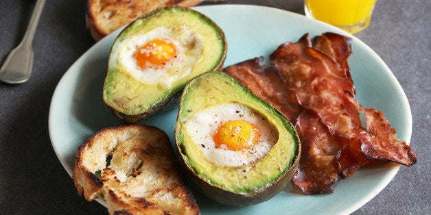 Breakfast with eggs baked in avocado,bacon ,bread toast and orange juice