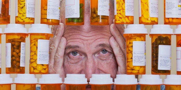 Depressed Senior Man Looking Through Rows of Prescription Medication