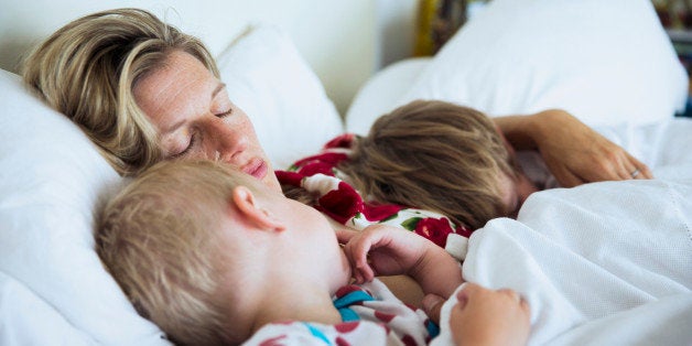 Mother with sons sleeping in bed