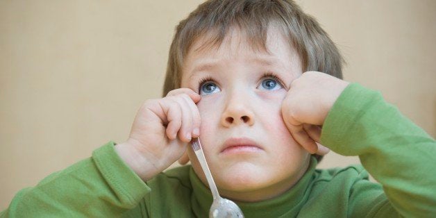 Portrait young boy gazing upwards, while eating