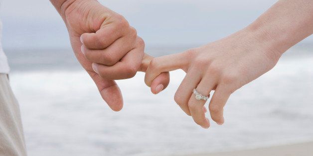 Hispanic couple holding hands on beach