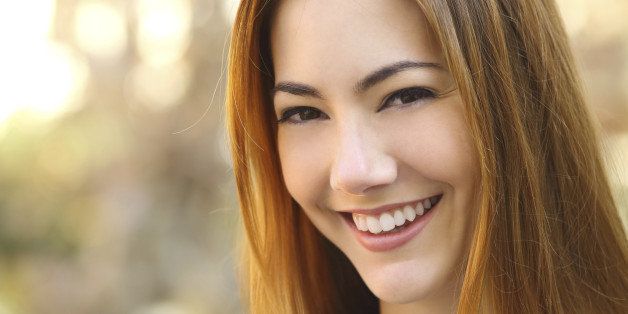 Portrait of a beautiful happy woman with a perfect white smile with a warmth background