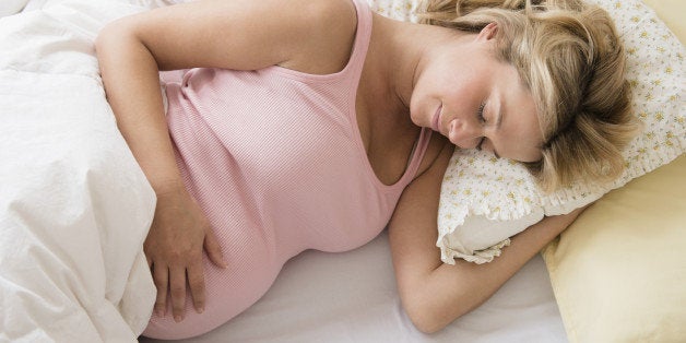 Pregnant woman asleep in bed