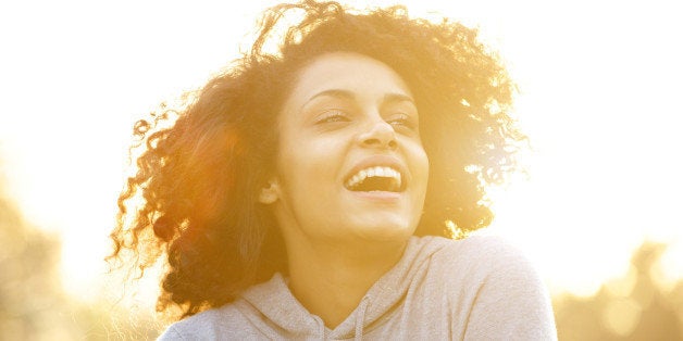 Close up portrait of a happy african american girl laughing outdoors