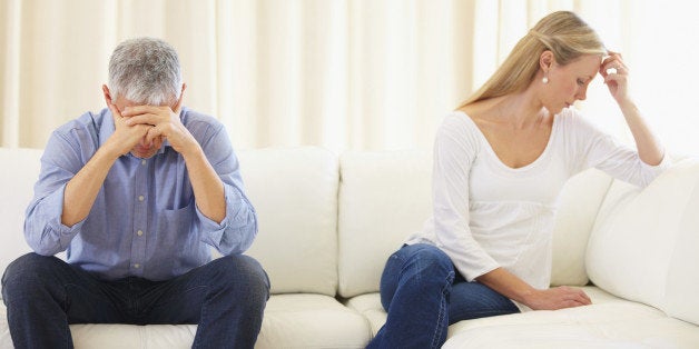 Upset married couple sitting on the sofa after a disagreement