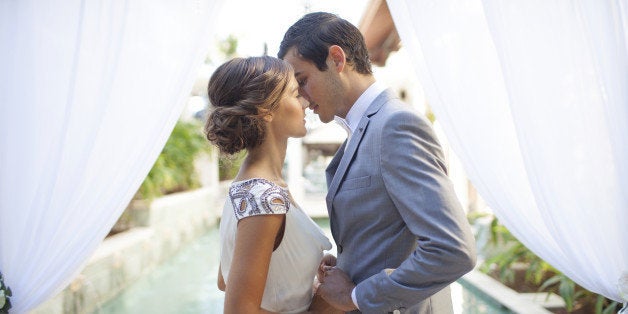 Bride and groom kissing at wedding alter