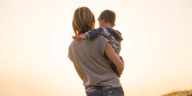 Mother holding son in rural field