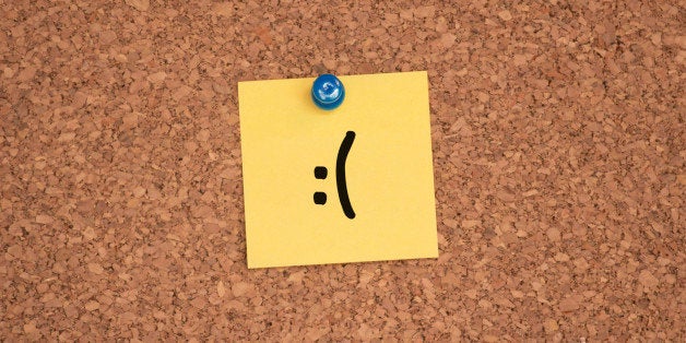 A frowning face drawn on a post-it.
