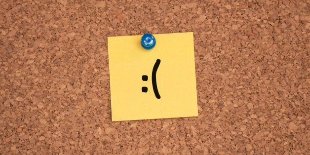 A frowning face drawn on a post-it. 