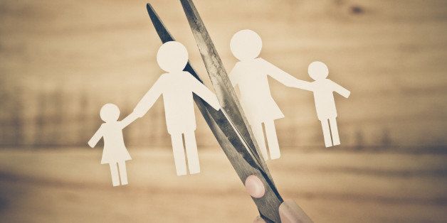 Hand with scissors cutting paper cut out with family member shape / Family problem / Divorce concept