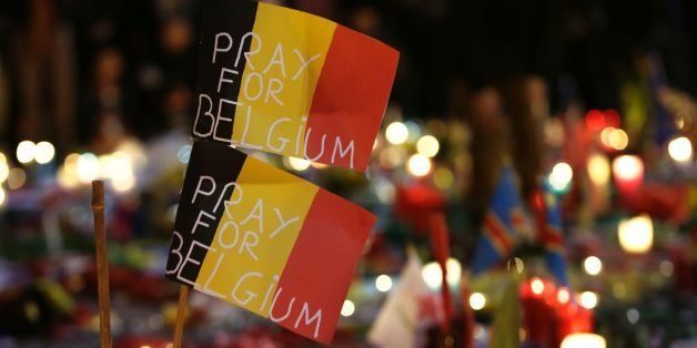 Belgian flags reading 'Pray for Belgium' are pictured as people gather at a makeshift memorial on the Place de la Bourse (Beursplein) in Brussels on March 23, 2016, a day after a triple bomb attack, which responsibility was claimed by the Islamic State group, left 31 dead and hundreds injured in the Belgian capital. World leaders united in condemning the carnage in Brussels and vowed to combat terrorism, after Islamic State bombers killed 31 people in a strike at the symbolic heart of the EU. AFP PHOTO / KENZO TRIBOUILLARD / AFP / KENZO TRIBOUILLARD (Photo credit should read KENZO TRIBOUILLARD/AFP/Getty Images)