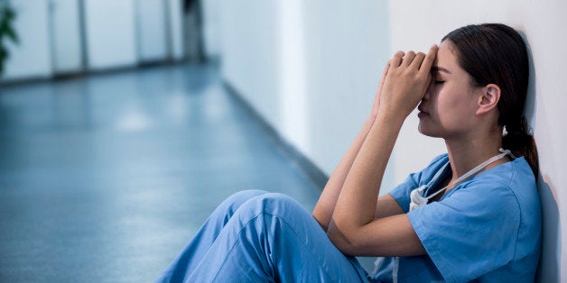 Exhausted surgeon sitting on floor