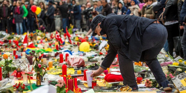 A man lays a candle as people gather to pay tribute to the victims of the Brussels attacks on the Place de la Bourse (Beursplein) in central Brussels, on March 24, 2016, two days after a triple bomb attack, which responsibility was claimed by the Islamic State group, hit Brussels' airport and the Maelbeek - Maalbeek subway station, killing 31 people and wounding 300 others.
A grieving Belgium hunted two fugitive suspects after bombings that struck at the very heart of Europe, as security authorities faced mounting criticism over the country's worst-ever attacks.
/ AFP / PHILIPPE HUGUEN (Photo credit should read PHILIPPE HUGUEN/AFP/Getty Images)