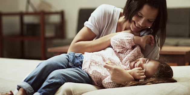 Mother and daughter having fun on sofa