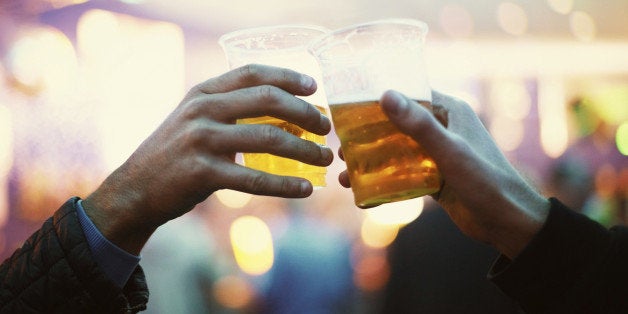 Two friends toasting to the good times with plastic cups of beer - Music Festival