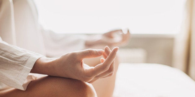 Hands of young beautiful woman practicing yoga indoors