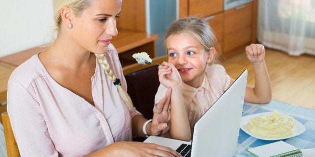 Tired businesswoman irritated as little daughter diverts her from laptop at home