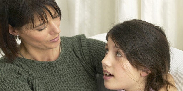 Woman embracing teenage daughter (14-16), looking at each other