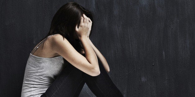 A studio shot of a young woman suffering from loneliness and depression