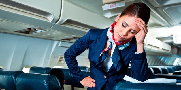 Young air stewardess suffering from headache on an airplane.