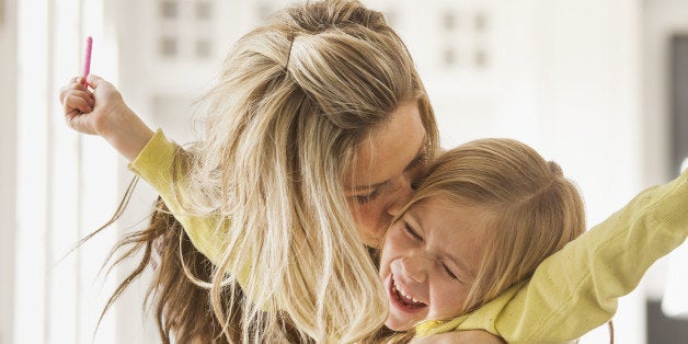 USA, Utah, Lehi, Mother kissing daughter (6-7) during doing homework