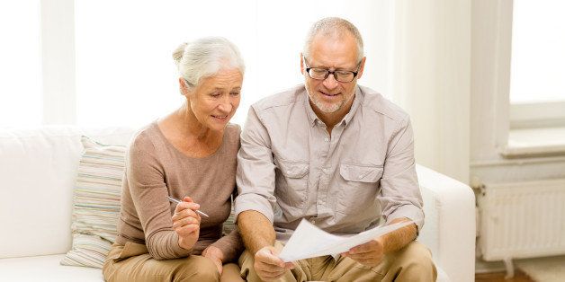 family, business, savings, age and people concept - smiling senior couple with papers and calculator at home