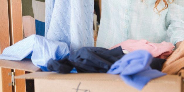 Pacific Islander woman putting donated clothing into box