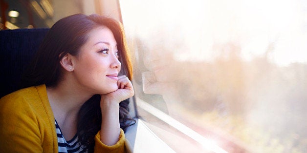 Woman on a train day dreaming out the window.