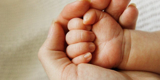 a parent holds the hand of a...