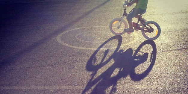 Long shadow of child riding a bicycle