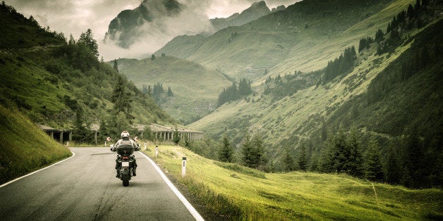 Motorcyclist on mountainous highway, cold overcast weather, Europe, Austria, Alps, extreme sport, active lifestyle, adventure touring concept