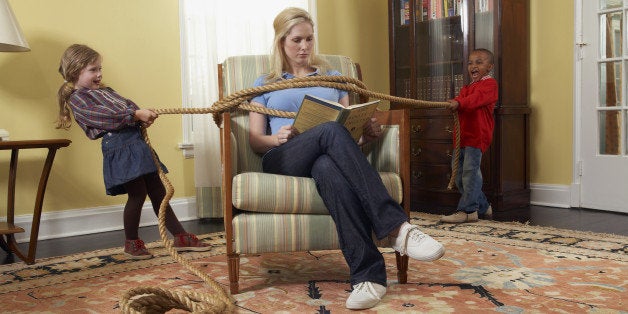 Boy and girl (5-7 years) tying mother with rope in living room