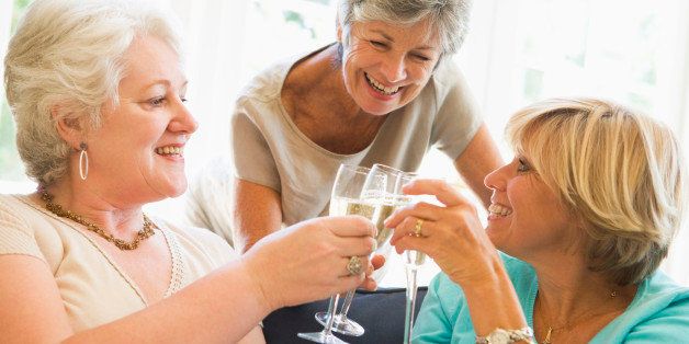 Three women in living room toasting champagne and smiling