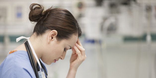 Nurse rubbing her forehead in hospital